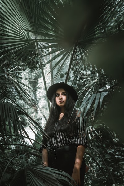 女子站在棕榈叶包围
